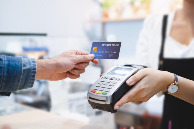 man holding a credit card in front of card reader