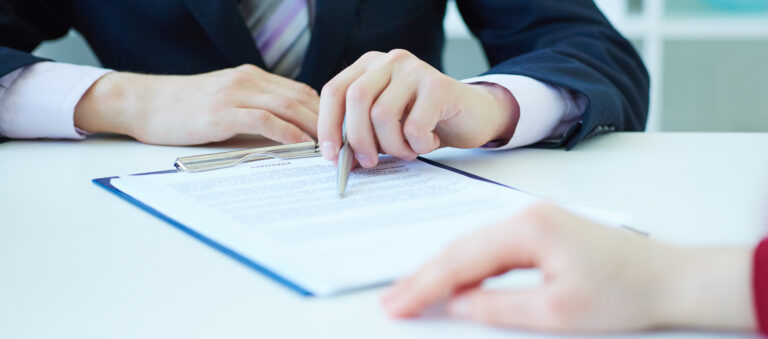 business persion and a clipboard with paperwork to sign